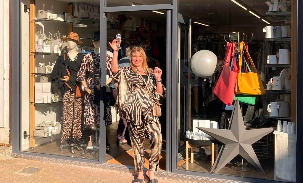 owner and founder Louie Buckley stood outside Be You Lifestyle Boutique at 54 Deardengate Haslingden in Rossendale Lancashire with a glass of fizz in her hand on her opening day 19th March 2022