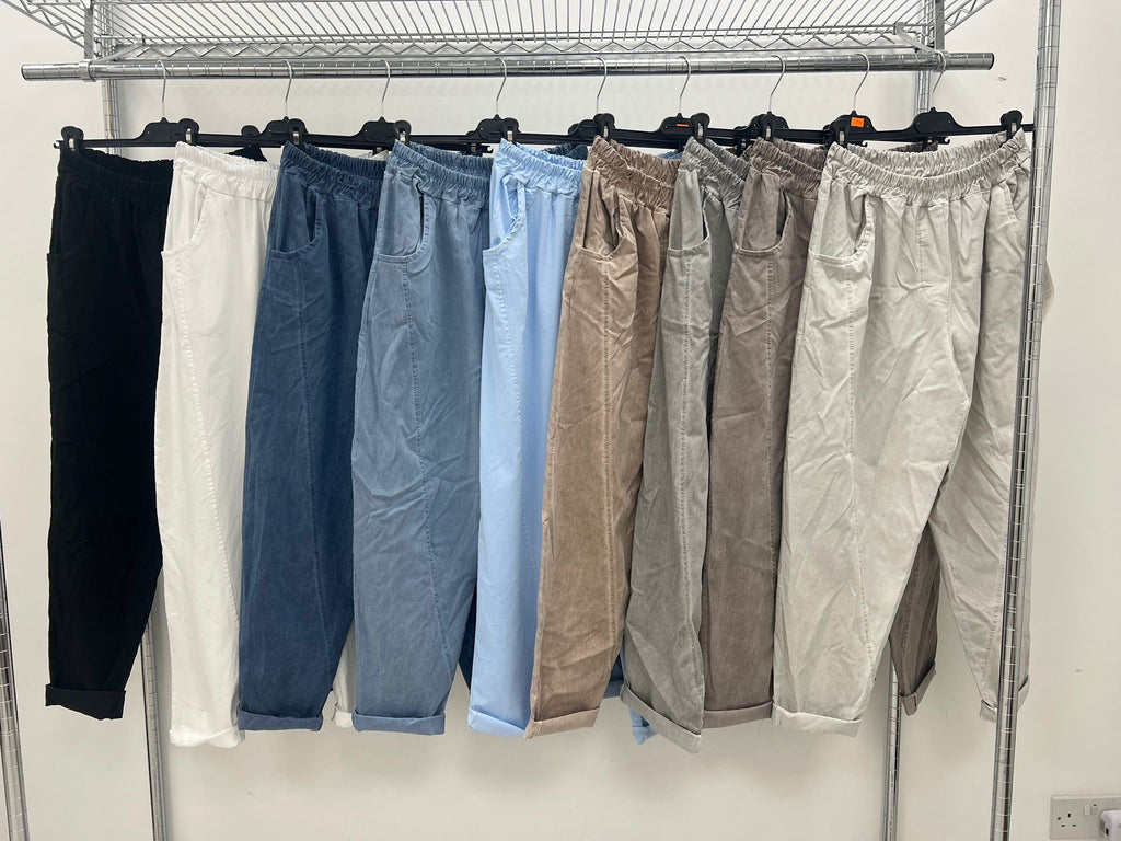 rail of acid wash relaxed magic trousers in black, white, dark denim, light denim, fawn, khaki and white